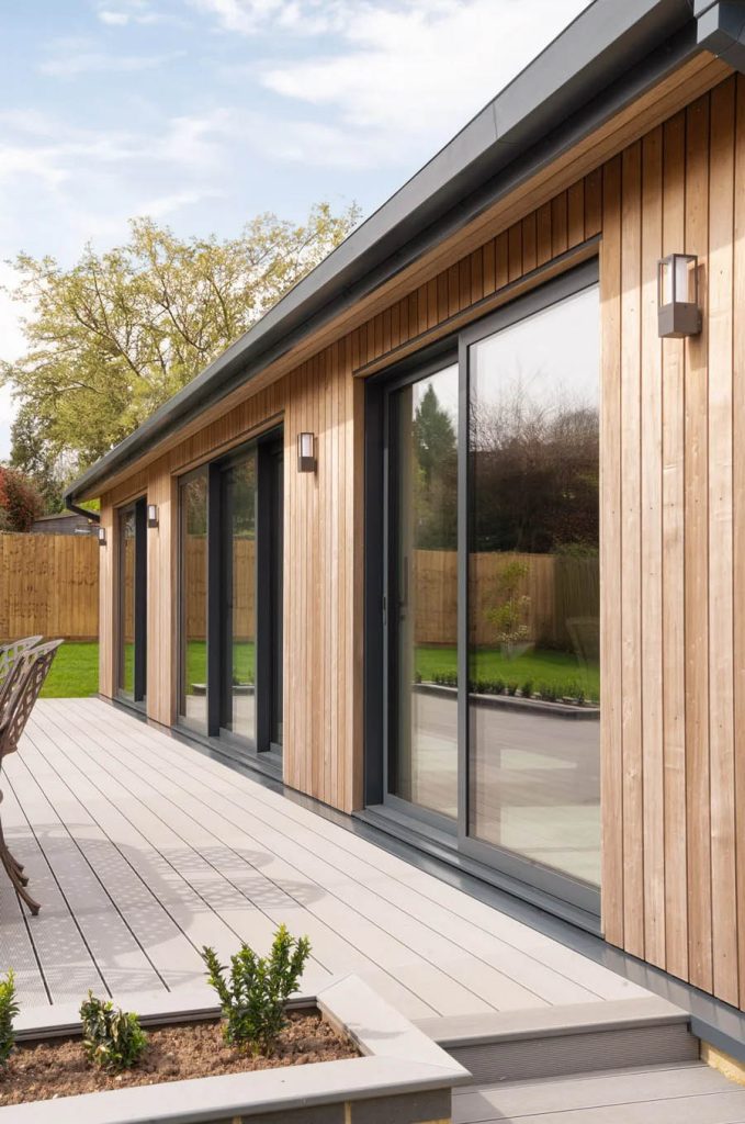 What are patio doors and why are they popular in modern homes? 2 Sliding Patio Doors on a wood finished patio and a modern garden